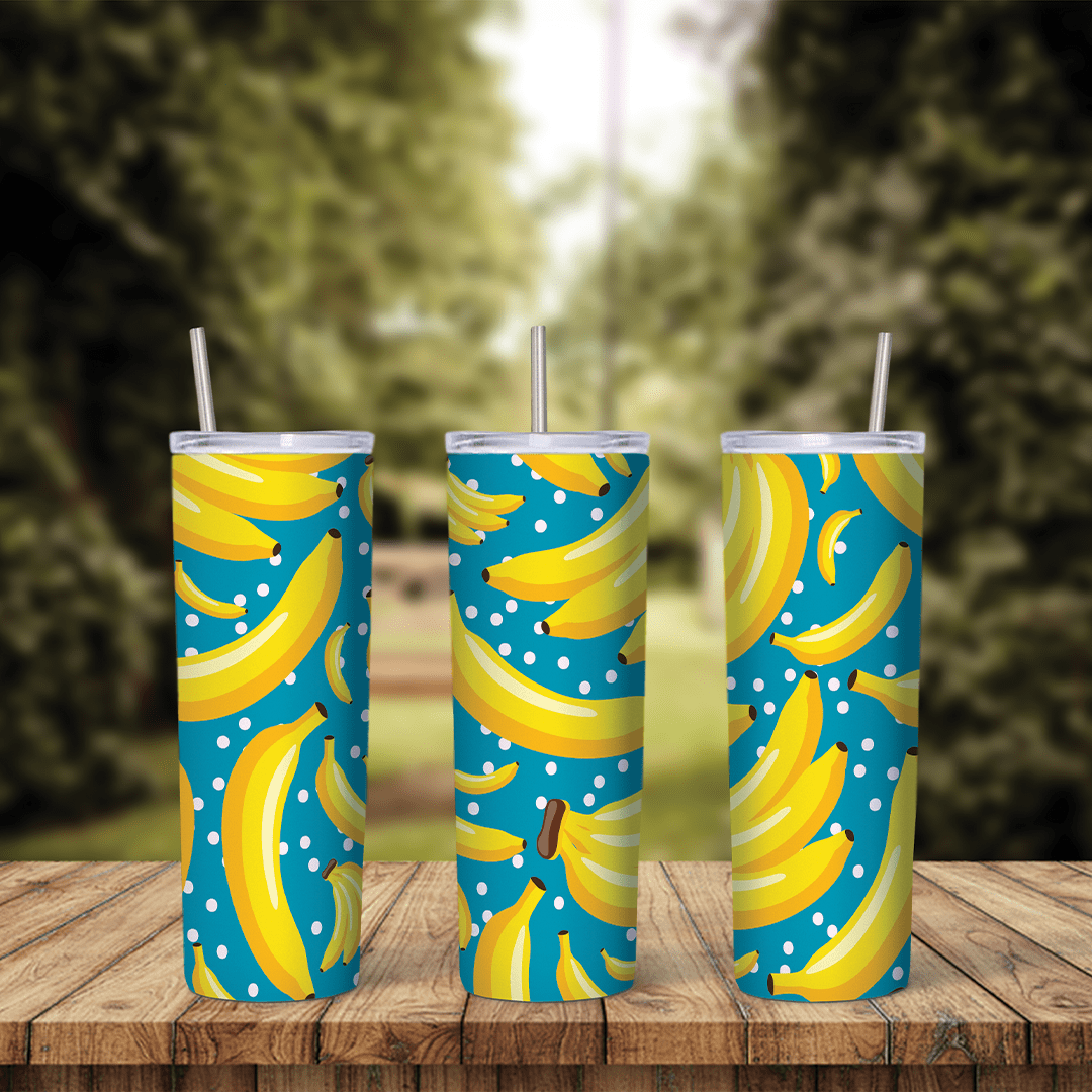 A full 20 oz skinny tumbler wrap with a pattern of yellow bananas and white polka dots on a teal blue background. Sublimation design