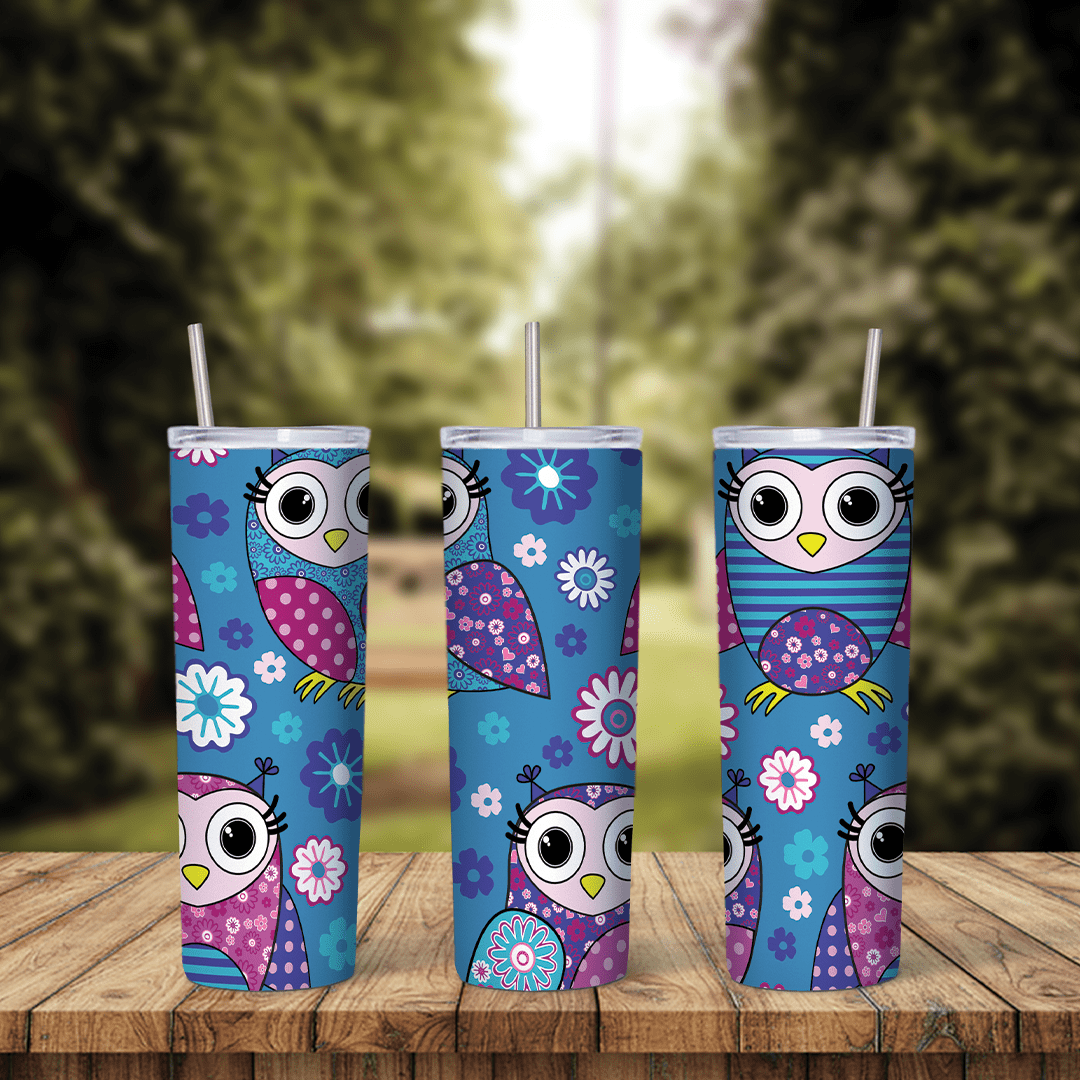 A blue 20 oz tumbler wrap with cartoon owls in pink, purple and blue patchwork patterns, big round eyes and scattered flowers. Sublimation design