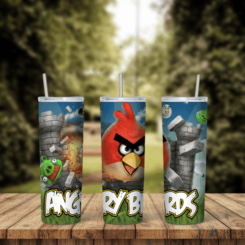 An Angry Birds tumbler wrap with Red flying past gray stone towers, a green pig and the Angry Birds logo in big letters along. Sublimation design