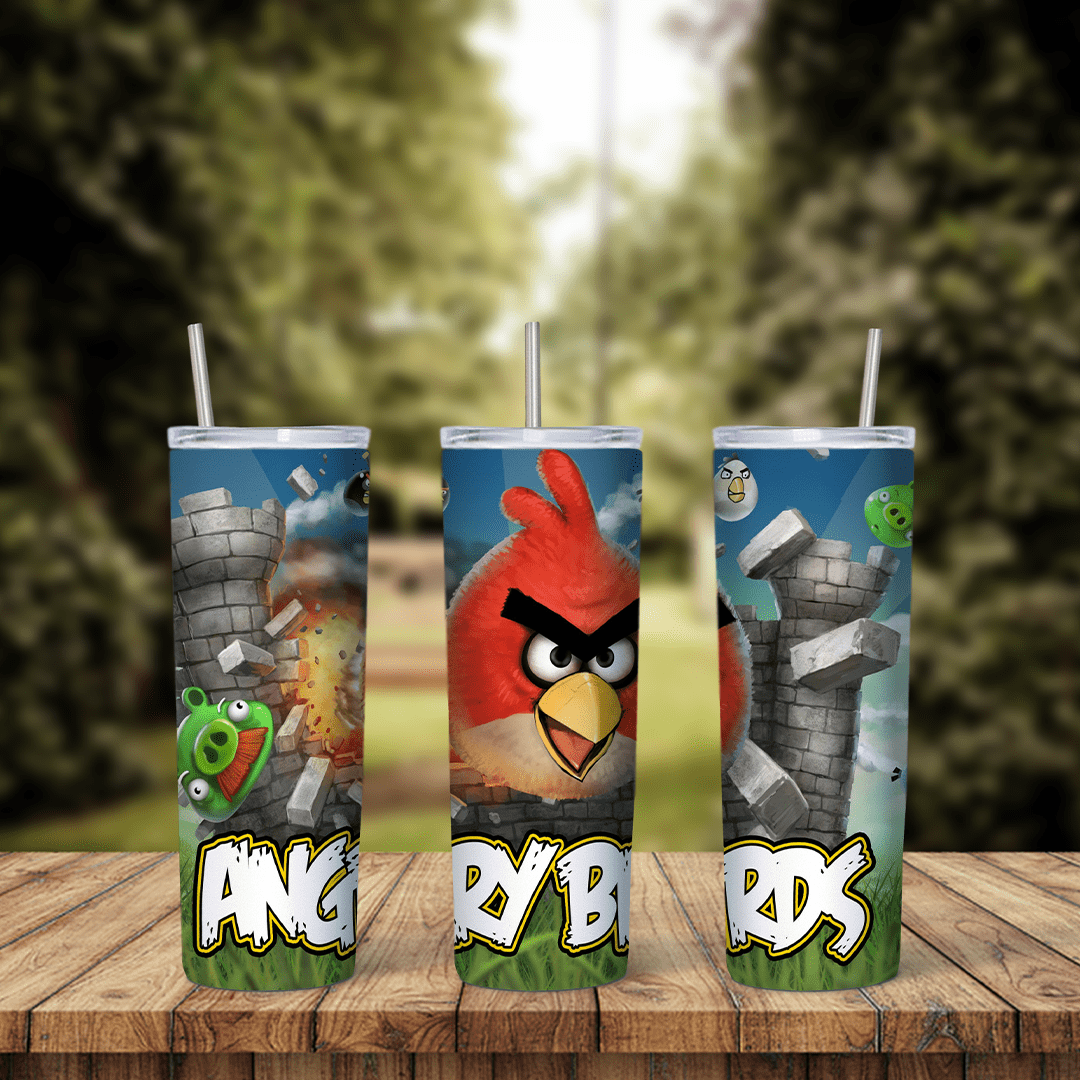 An Angry Birds tumbler wrap with Red flying past gray stone towers, a green pig and the Angry Birds logo in big letters along. Sublimation design