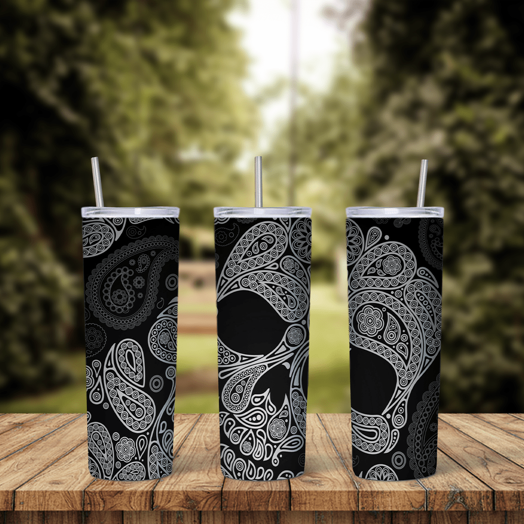 A skull tumbler wrap with a large skull made of gray paisley and bandana patterns on a black background. Sublimation design