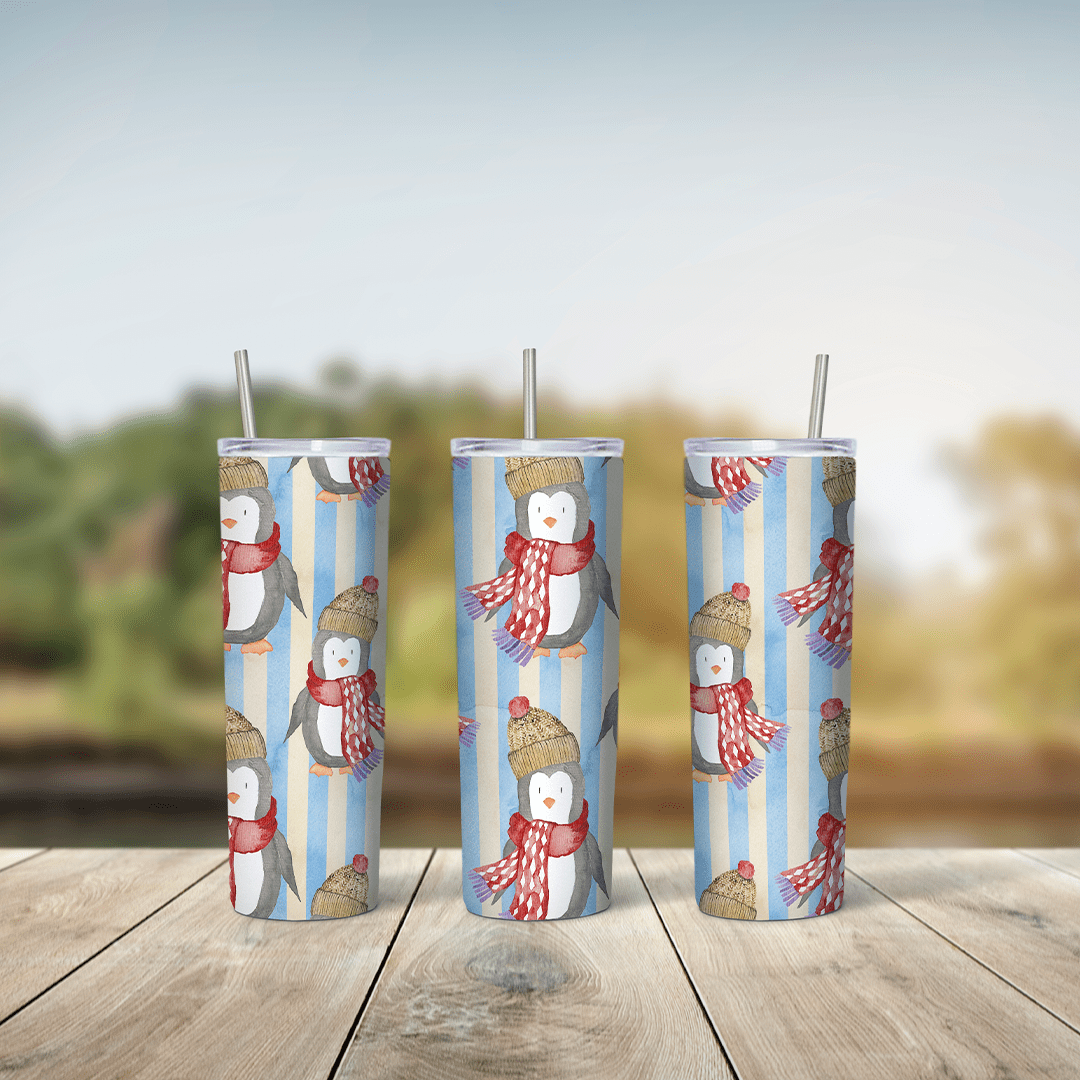 A full 20 oz skinny tumbler wrap with cute cartoon penguins in red scarves and knit hats, repeated over light blue and white. Sublimation design