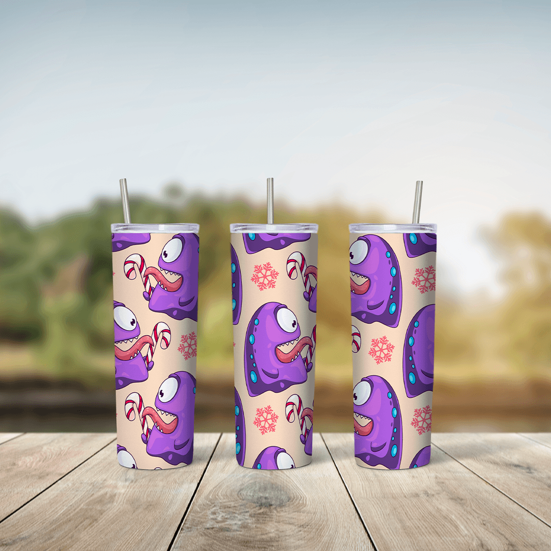 A 20 oz skinny tumbler wrap with cute purple one eyed cartoon monsters and pink flowers over a peach background. Sublimation design