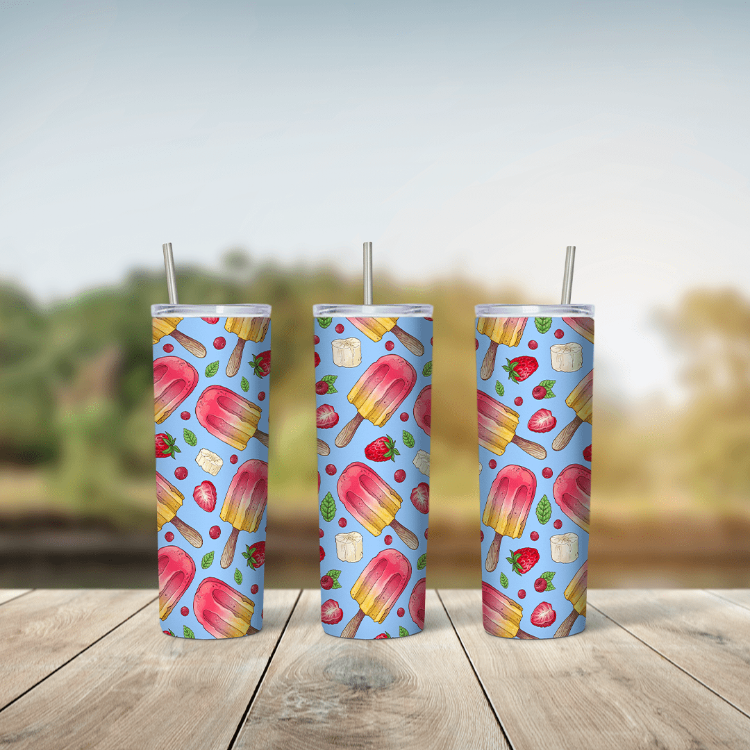 A full 20 oz skinny tumbler wrap with a pattern of pink and yellow popsicles, strawberries and fruit pieces on a light blue. Sublimation design