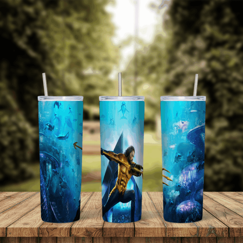 A full 20 oz skinny tumbler wrap of Aquaman in his gold and green suit holding a trident, swimming through a deep blue ocean. Sublimation design