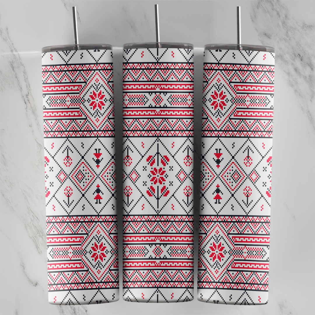 A 20 oz skinny tumbler wrap with a white folk embroidery pattern: red and black cross-stitch borders, diamonds and stylized. Sublimation design