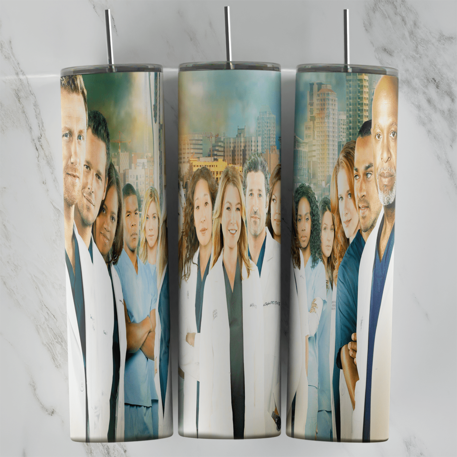 A Grey’s Anatomy tumbler wrap showing the cast standing together in white coats and scrubs in front of a soft blurred background. Sublimation design