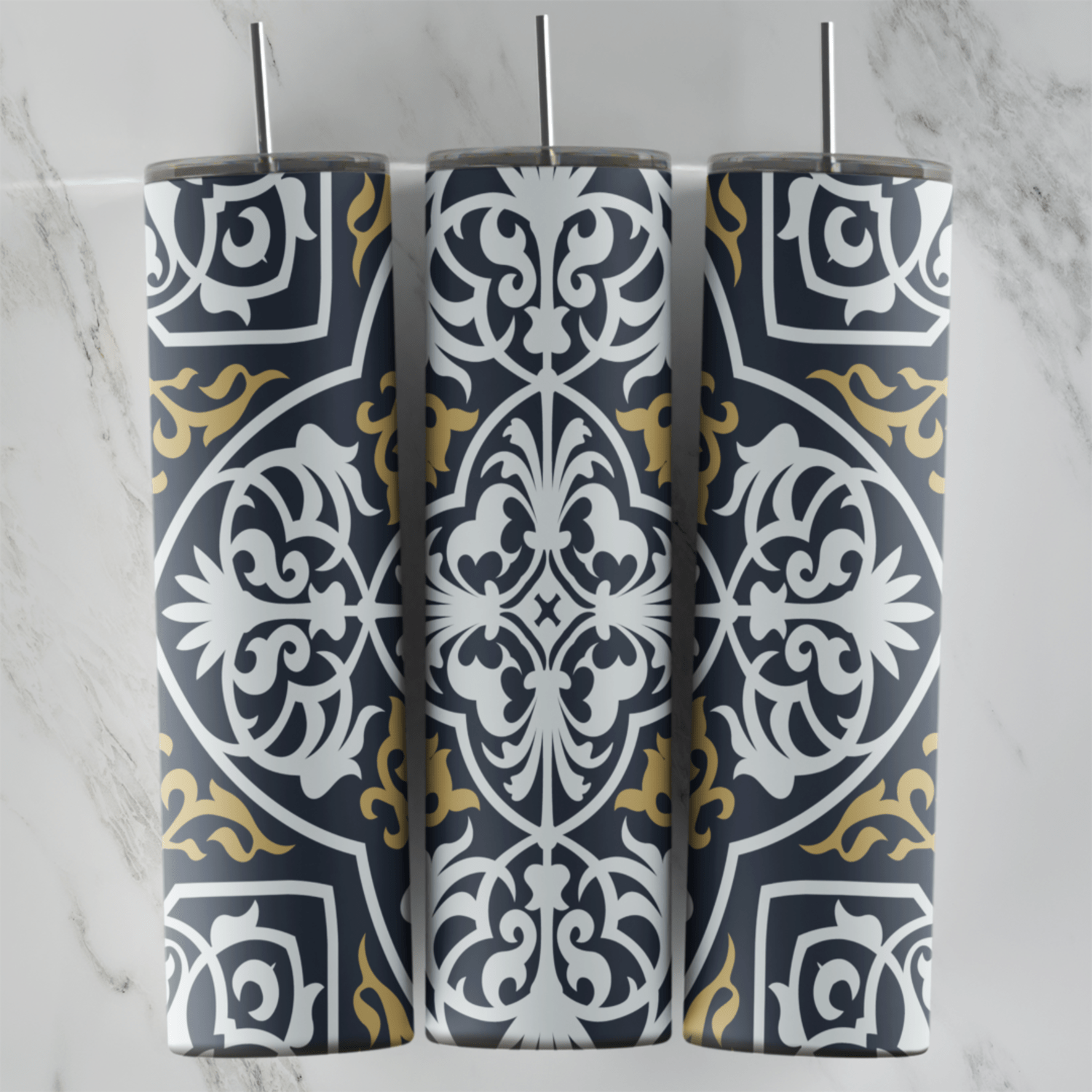A 20 oz skinny tumbler wrap with a dark tile arabesque pattern: white carved style medallions and gold corner scrolls on charcoal. Sublimation design